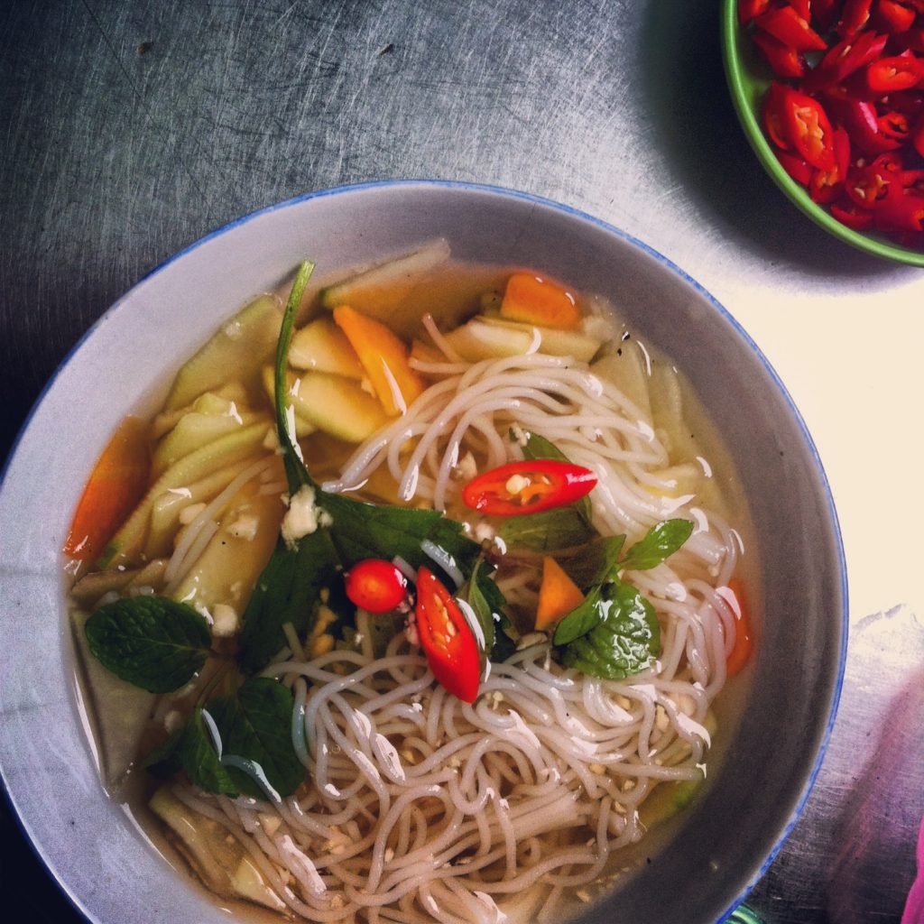 bowl of soup with noodles and herbs