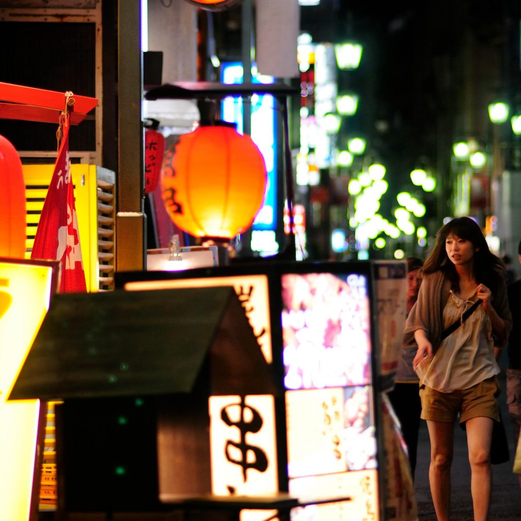 woman walking down tokyo street at night