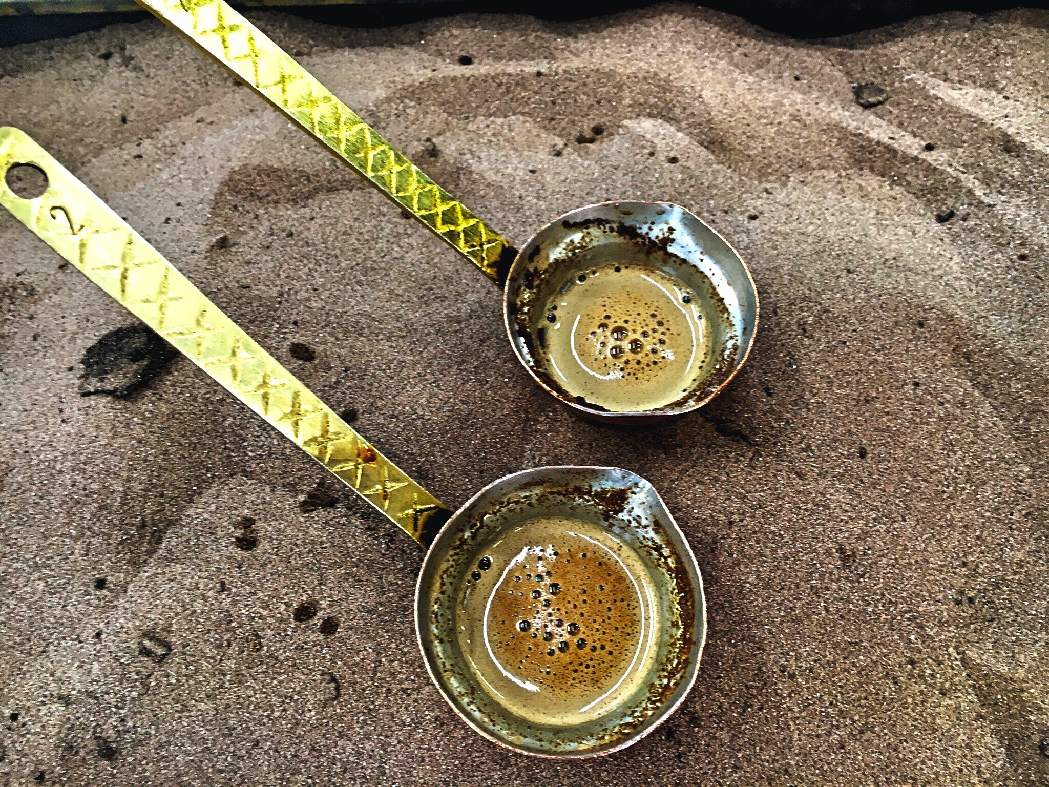 traditional Greek coffee being brewed over sand