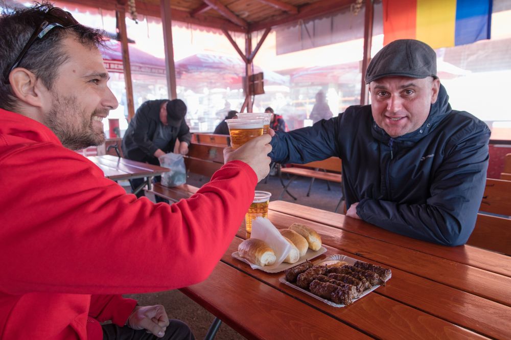 two men cheersing with beers
