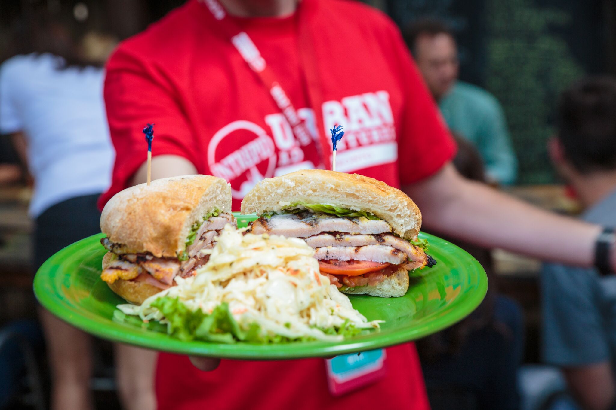 Urban Adventures guide holding a plate of bacon sandwiches